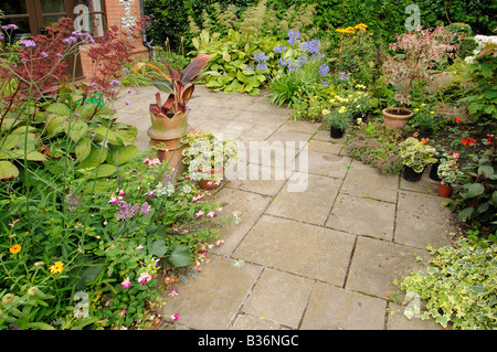 Summer courtyard with mixed flowering and herbaceous borders Norfolk UK August Stock Photo