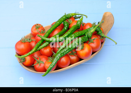 Freshly picked home grown organic Tomatoes Chillies in a rustic wooden bowl Stock Photo