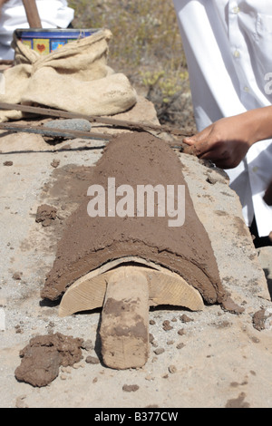 Learning how to make the half round roof tiles the wet clay sits on the mould where it will dry in the sun, Chirche, Guia de Isora, Tenerife Stock Photo