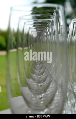 A row of empty champagne glasses, outside at a wedding reception, appears to go to infinity. Stock Photo