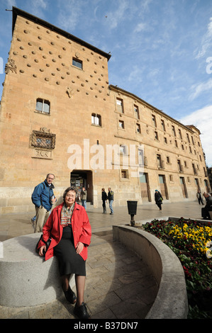 Lady sitting in front of the House of Shells Casa de las Conchas Salamanca Spain Stock Photo