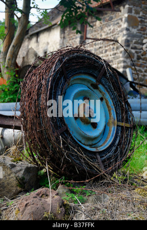 Barbed wire wrapped around a wheel on a French farm Stock Photo