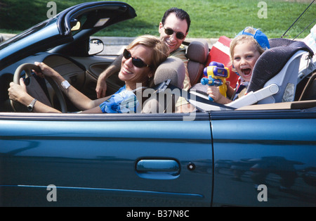 Family in convertable car driving together, car packed for vacation Stock Photo