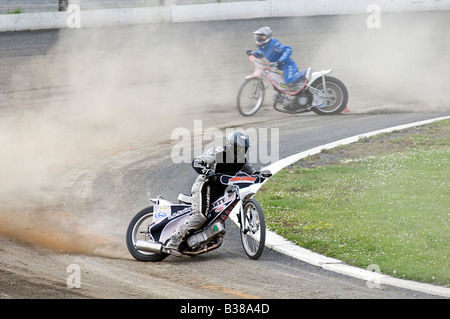 speedway riders sliding through a corner Stock Photo