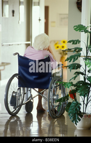 senior old timer sitting in a wheelchair from behind alone in a floor of a retirement home LONELINESS Germany Stock Photo