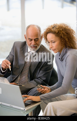 African businesspeople looking at laptop Stock Photo
