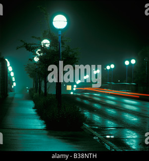 many lighted street lamps reflection on wet lane dissipation of energy, Germany Stock Photo