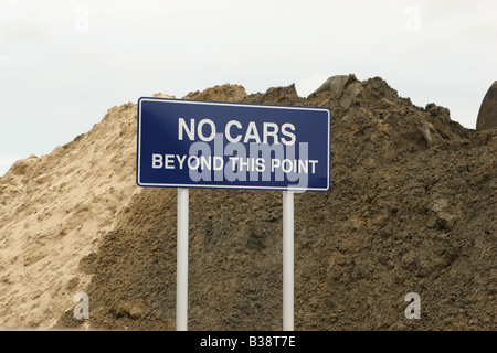 Sign in front of a sand obstacle stating no cars beyond this point Stock Photo