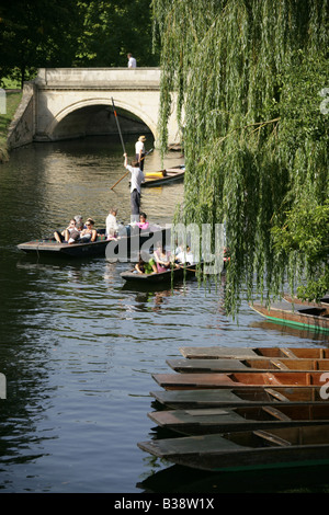 City of Cambridge, England. Hire punts moored on the River Cam with tourists pleasure punting in the background.