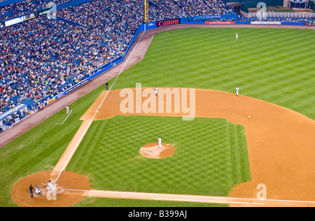 THE BRONX, New York City, United States — A baseball game is in progress at the old Yankee Stadium, with the New York Yankees facing off against the Baltimore Orioles. The iconic venue, known as 'The House That Ruth Built,' hosts a crowd of passionate fans watching America's pastime. The historic stadium, with its distinctive facade and Monument Park, provides a backdrop steeped in baseball lore as two American League East rivals compete on the diamond. Stock Photo