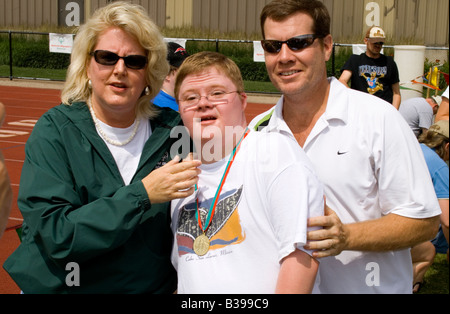 Parents pose with athlete son after winning medal. Special Olympics U of M Bierman Athletic Complex. Minneapolis Minnesota USA Stock Photo