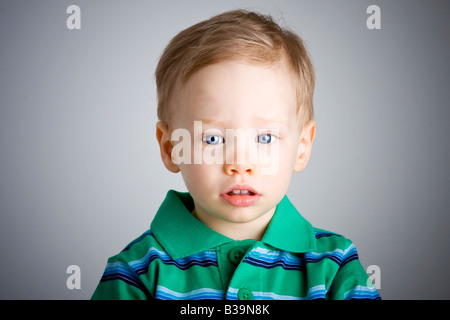 Sad boy with big blue eyes looking away from the camera Stock Photo