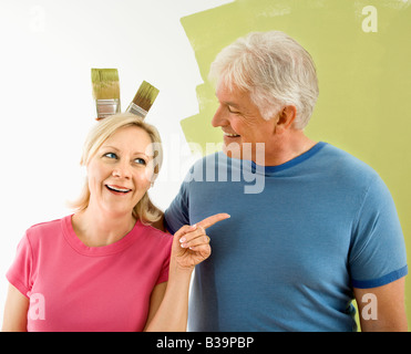Happy woman in bunny ears with toy carrots on pink background. Easter ...
