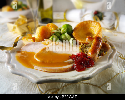 Traditional roast turkey Christmas dinner with all the trimmings and roast potatoes, plated & erved in a festive table  setting Stock Photo