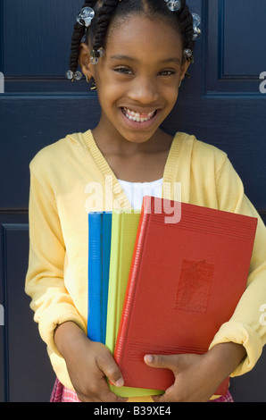School Girl holding books standing at school Stock Photo - Alamy