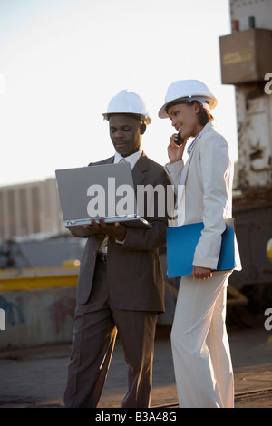 African American businesspeople wearing hardhats Stock Photo