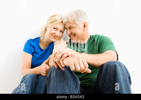 Middle aged couple sitting together smiling Stock Photo