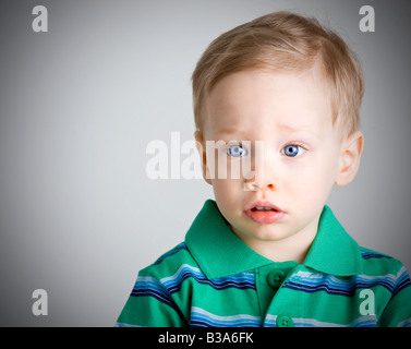 Sad boy with big blue eyes looking away from the camera Stock Photo