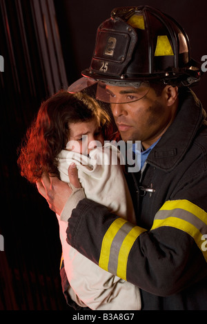 Hispanic male firefighter holding child Stock Photo