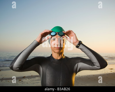 Hispanic woman wearing wetsuit and goggles