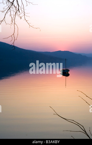 A single boat alone on a lake in the Arctic Circle at dusk Stock Photo