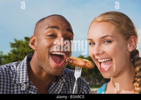 Multi-ethnic couple eating from same fork Stock Photo