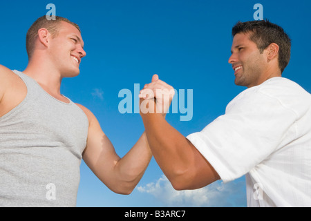 Multi-ethnic men clasping hands Stock Photo
