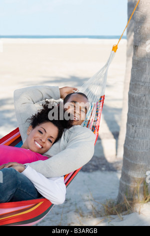 Hispanic couple laying in hammock Stock Photo