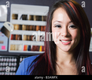 Asian woman in front of hair dye samples Stock Photo
