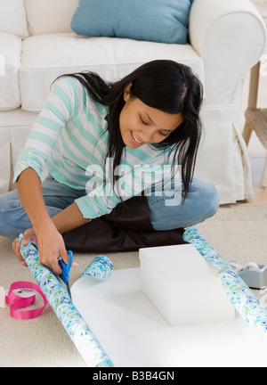 Pacific Islander woman wrapping gift Stock Photo