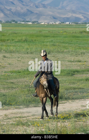 Kyrgyz Man on Horseback on the Road to the Torugart Pass in Kygryzstan Stock Photo