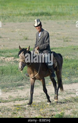 Kyrgyz Man on Horseback on the Road to the Torugart Pass in Kygryzstan Stock Photo