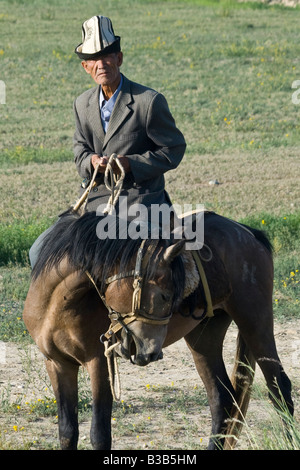 Kyrgyz Man on Horseback on the Road to the Torugart Pass in Kygryzstan Stock Photo