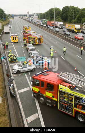 emergency services attending a nasty road traffic accident on a motorway as traffic tails back on the opposite carriageway Stock Photo