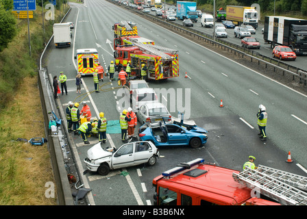 emergency services attending a nasty road traffic accident on a motorway as traffic tails back on the opposite carriageway Stock Photo