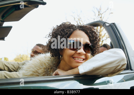 African couple driving in convertible car Stock Photo