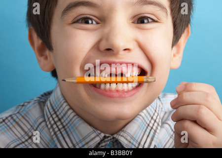 Portrait of Boy With Missing Teeth, Biting Pencil Stock Photo