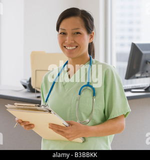 Asian female doctor holding chart Stock Photo