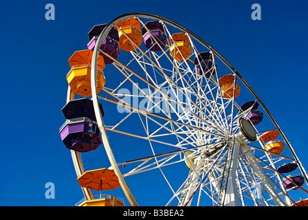 Pacific Park, Santa Monica CA pier family amusement park large Ferris wheel Roller Coaster moving over the ocean Stock Photo