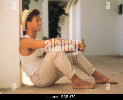Young man relaxing on holiday. Sitting on terrace. Stock Photo