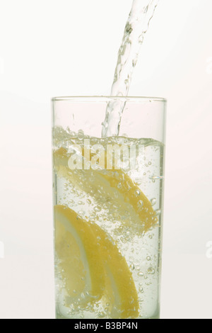 Water Pouring into Glass with Lemons Stock Photo