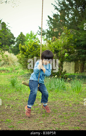 Little Boy on Rope Swing, Puttenham, Surrey, England Stock Photo