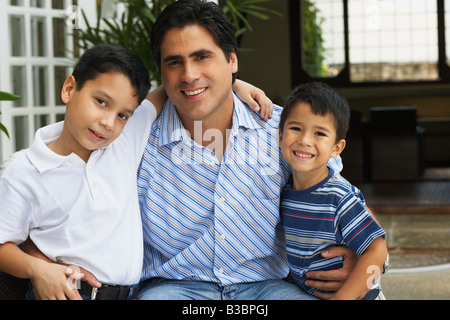 Hispanic father hugging sons Stock Photo