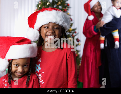 African sisters wearing Santa Claus hats Stock Photo