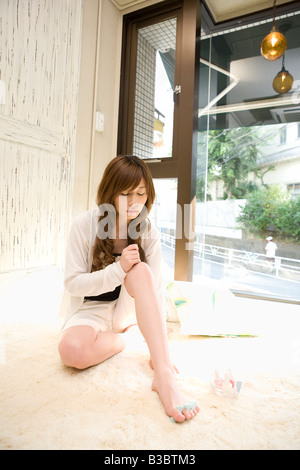 Young woman painting toe nails Stock Photo