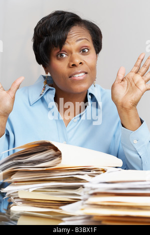 African businesswoman behind stacks of folders Stock Photo