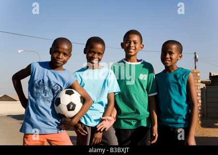 african boys playing soccer in the street Stock Photo