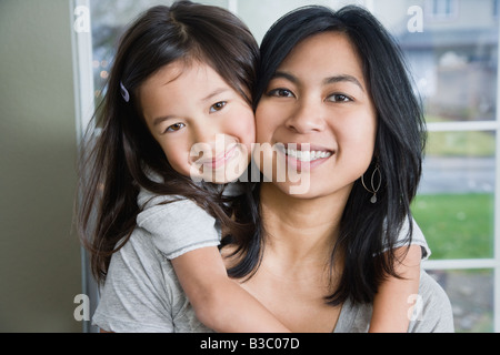 Mixed Race mother and daughter hugging Stock Photo