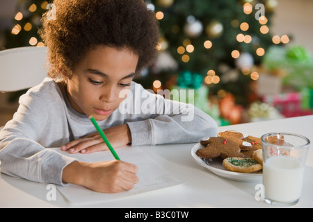 Mixed Race boy writing letter to Santa Claus Stock Photo