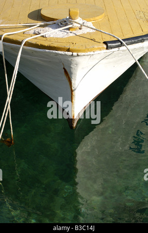 Front of a small boat reflected in water Stock Photo